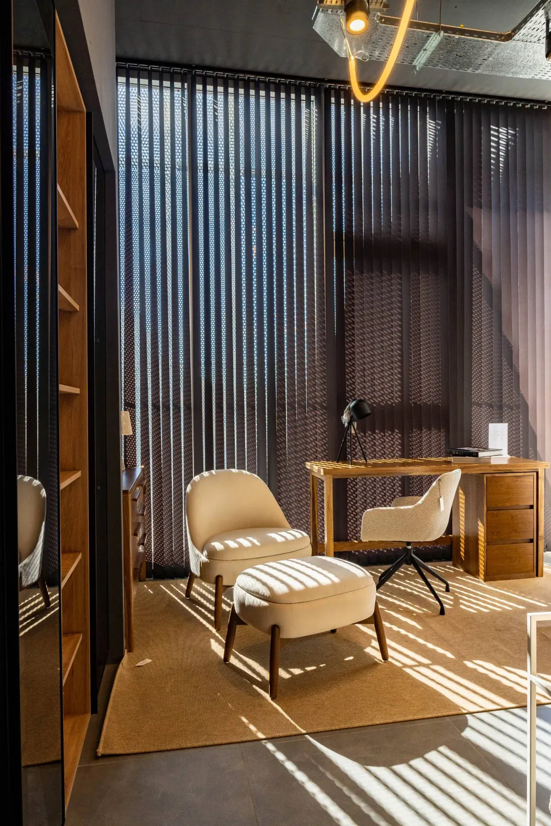 Cortinas de bandas verticales oscuras en un escritorio con luz natural